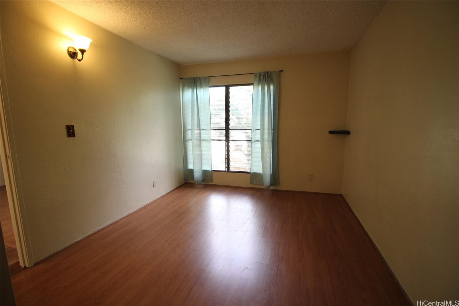 87-126 Helelua Street, Unit D204 Waianae, HI 96792 - Photo 11 of 13 an empty room with wooden floor and windows