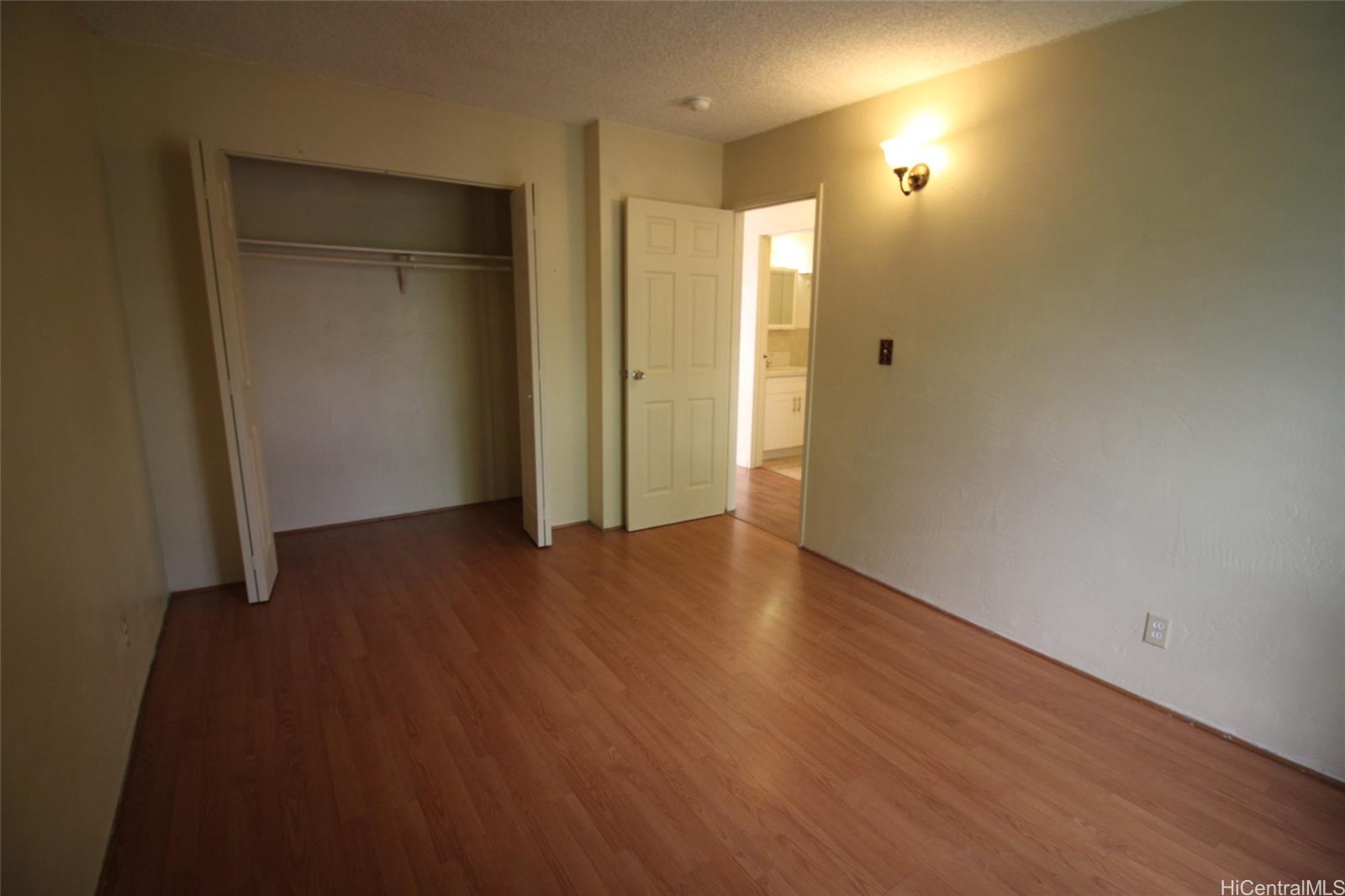 87-126 Helelua Street, Unit D204 Waianae, HI 96792 - Photo 13 of 13 an empty room with wooden floor and closet area