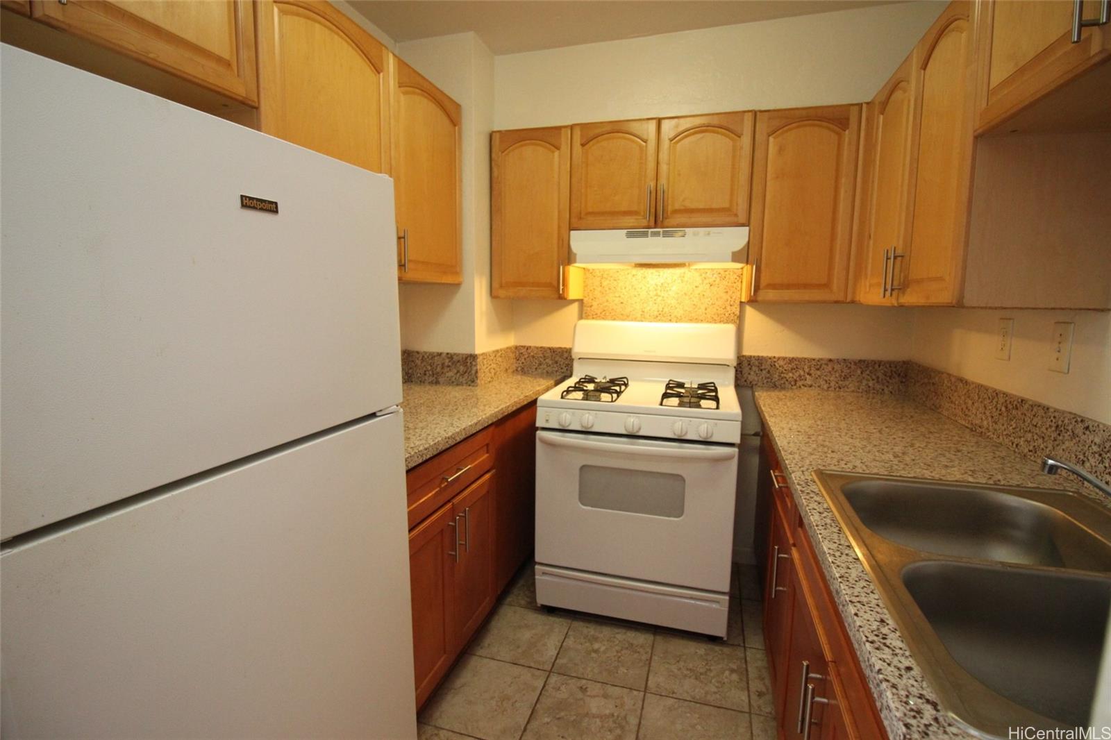 87-126 Helelua Street, Unit D204 Waianae, HI 96792 - Photo 2 of 13 a kitchen with a refrigerator sink and cabinets