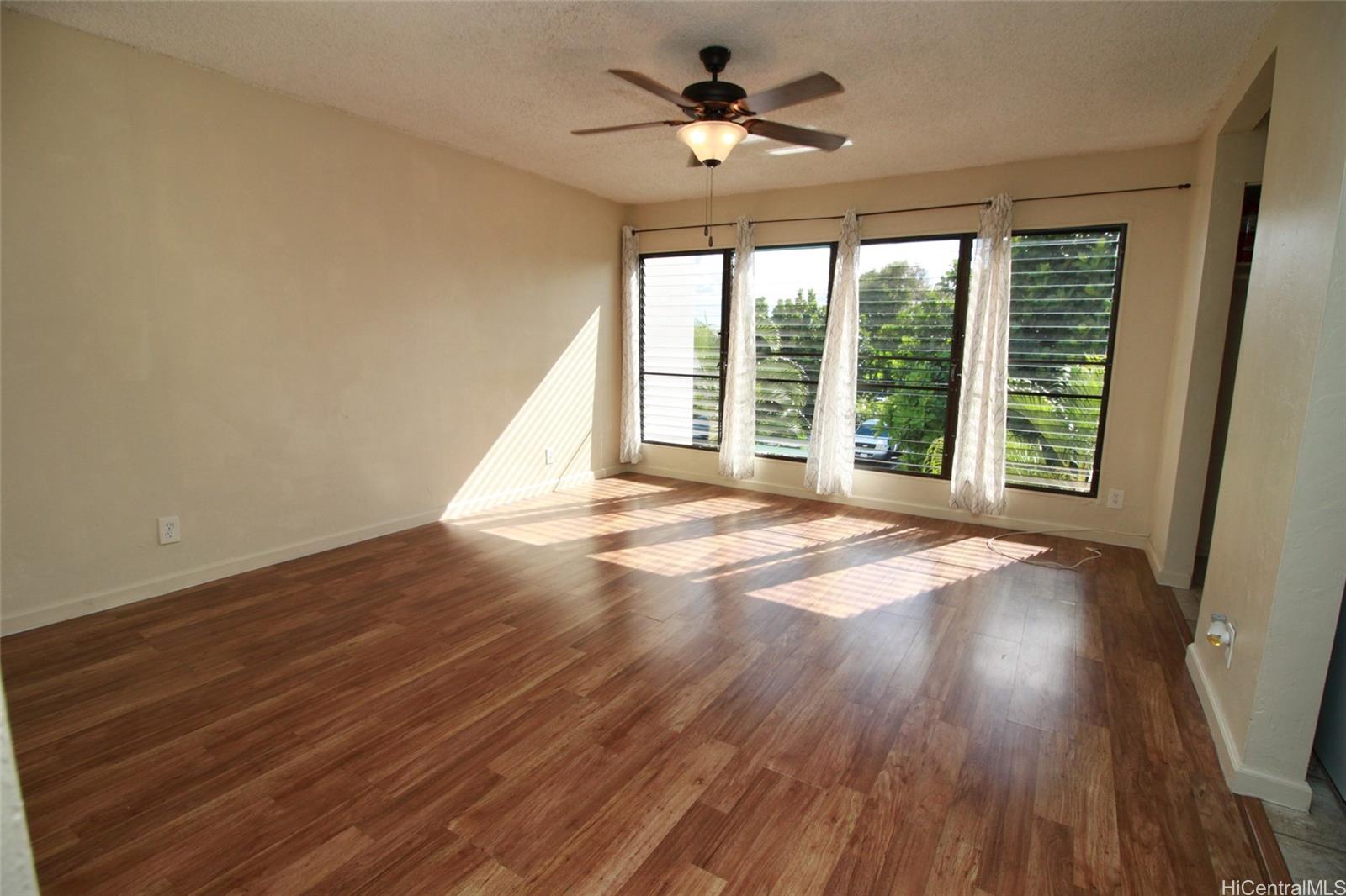 87-126 Helelua Street, Unit D204 Waianae, HI 96792 - Photo 3 of 13 a view of an empty room with wooden floor and a window