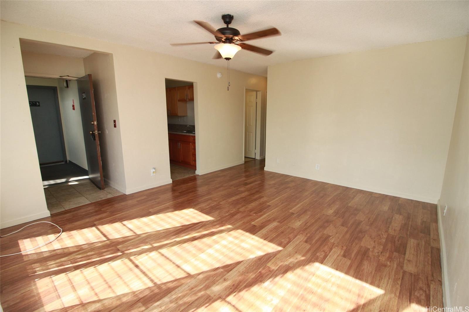 87-126 Helelua Street, Unit D204 Waianae, HI 96792 - Photo 5 of 13 a view of a room with wooden floor and a ceiling fan