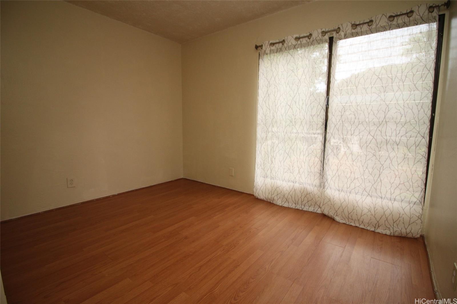 87-126 Helelua Street, Unit D204 Waianae, HI 96792 - Photo 7 of 13 a view of an empty room with wooden floor and a window