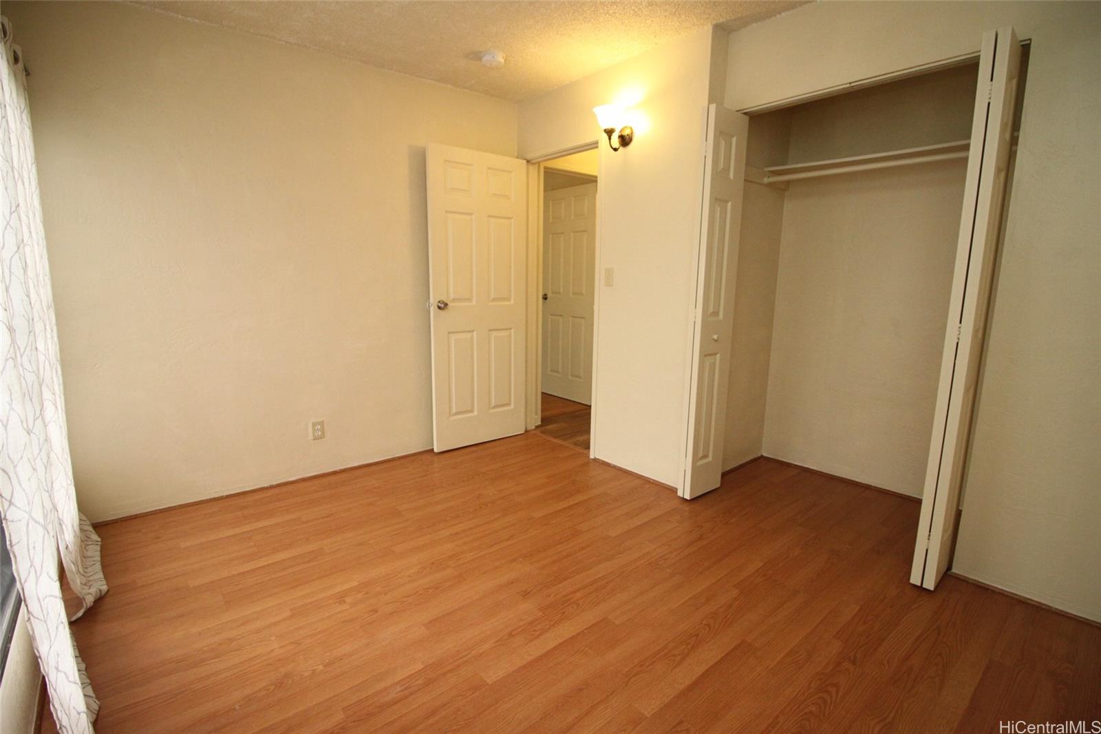 87-126 Helelua Street, Unit D204 Waianae, HI 96792 - Photo 9 of 13 a view of an empty room with wooden floor and a window
