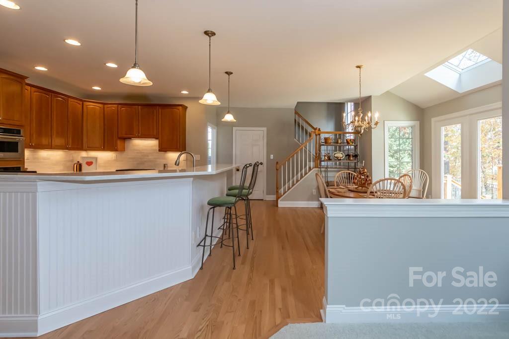 1629 Stevens Ridge Road Matthews, NC 28105 - Photo 19 of 39 a kitchen with stainless steel appliances granite countertop a sink a oven a dining table and chairs with wooden floor