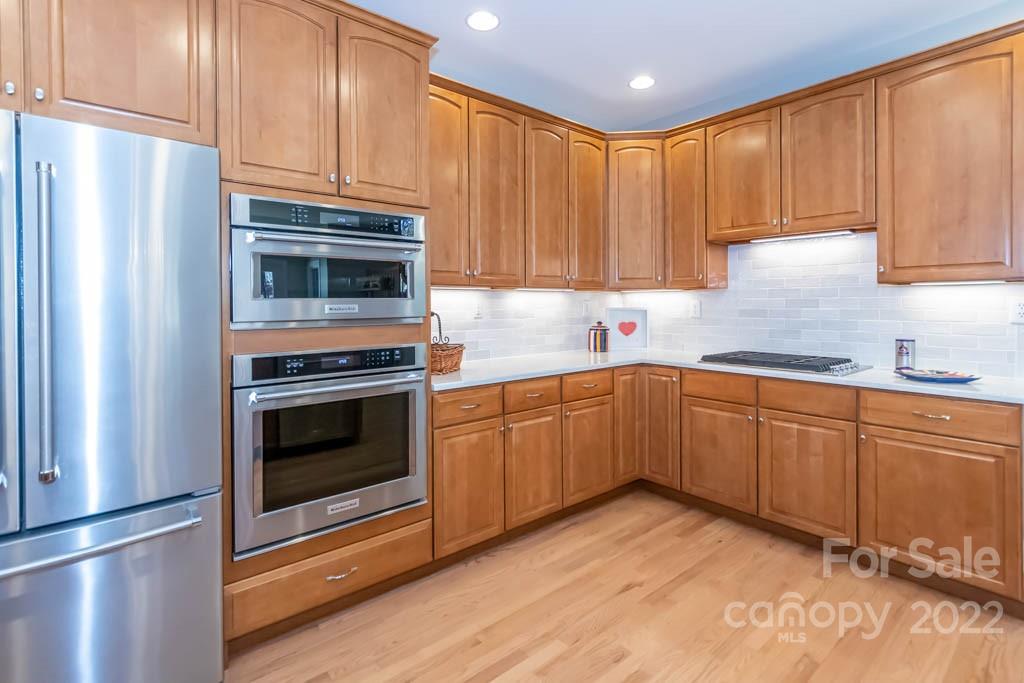 1629 Stevens Ridge Road Matthews, NC 28105 - Photo 22 of 39 a kitchen with granite countertop wooden cabinets stainless steel appliances and a counter space