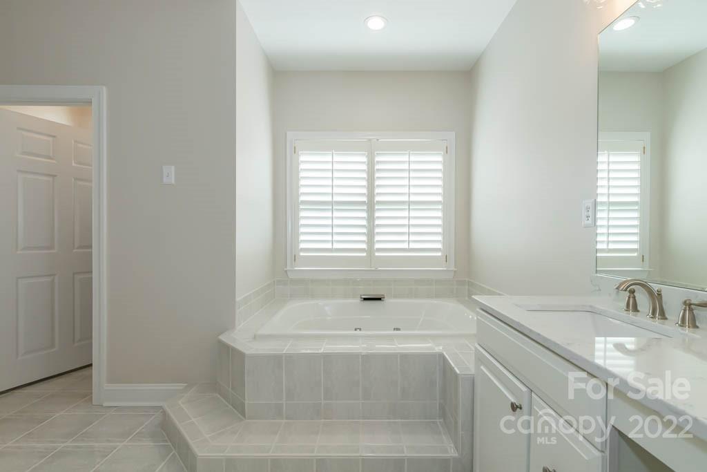 1629 Stevens Ridge Road Matthews, NC 28105 - Photo 29 of 39 a bathroom with a granite countertop sink and a bathtub