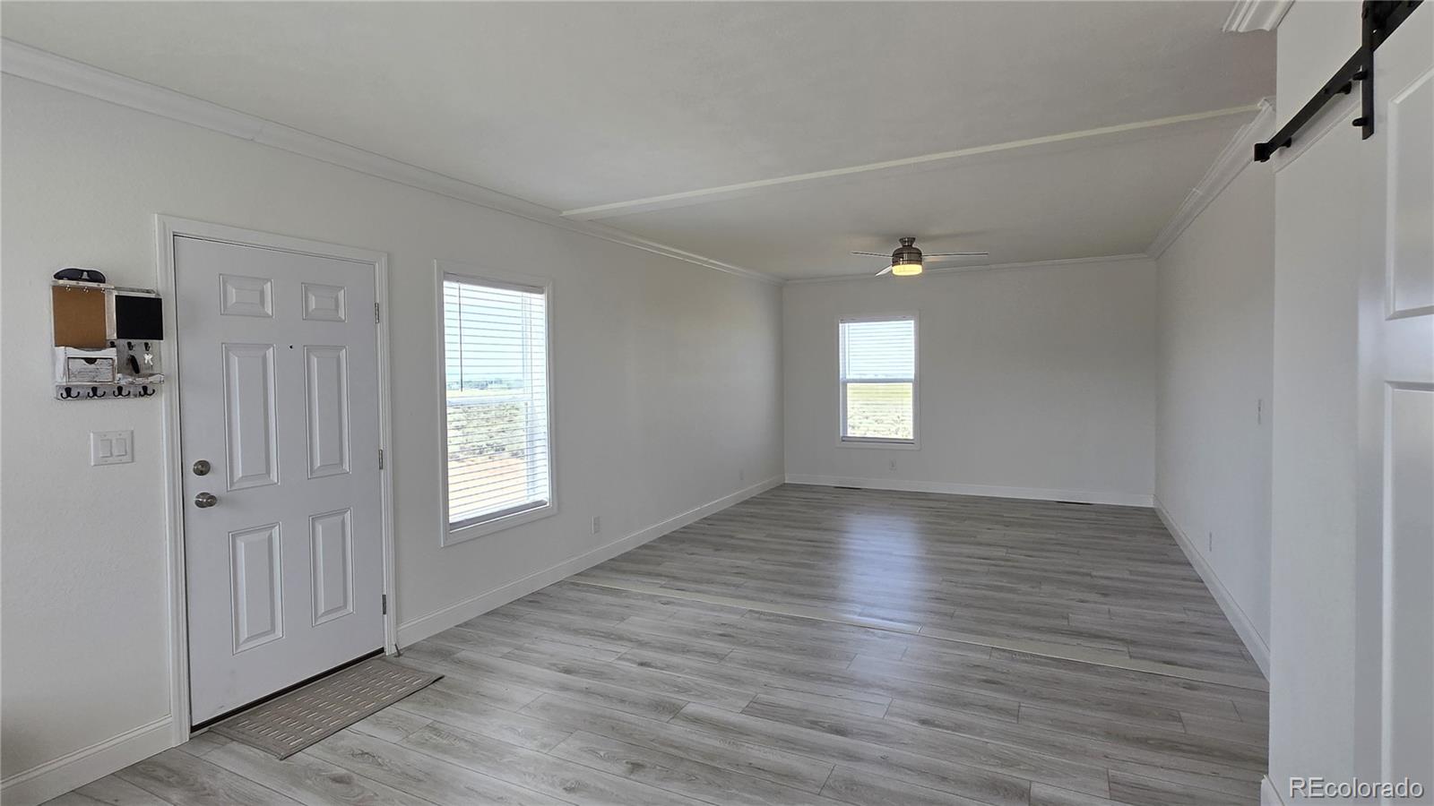 16383 Peacock Road Sanford, CO 81151 - Photo 13 of 33 a view of an empty room with wooden floor and a window