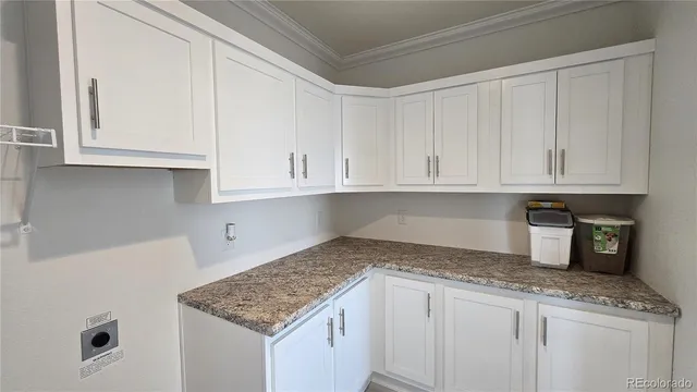 a kitchen with granite countertop white cabinets and a sink