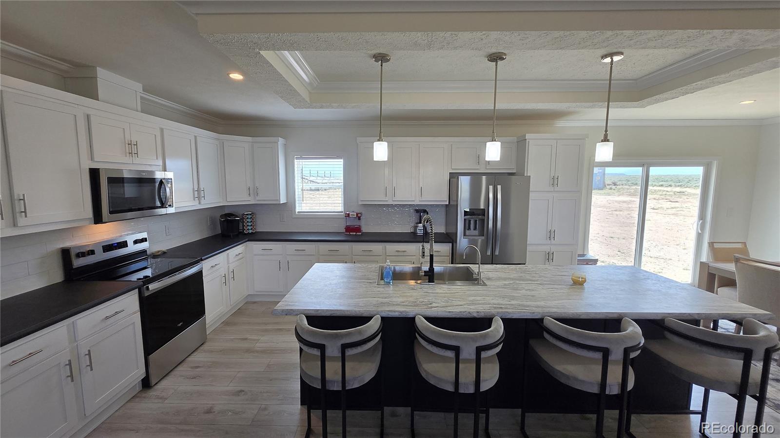 16383 Peacock Road Sanford, CO 81151 - Photo 4 of 33 a kitchen with stainless steel appliances granite countertop a stove top oven a sink a dining table and chairs
