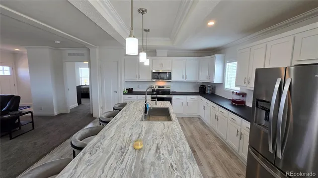 a large kitchen with cabinets a counter space a sink and stainless steel appliances