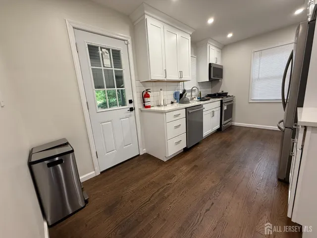 a kitchen with white cabinets and white appliances