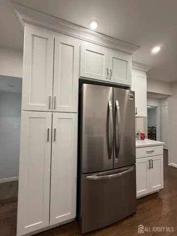a metallic refrigerator freezer sitting in a kitchen