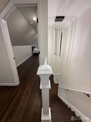 a view of hallway with stairs and wooden floor