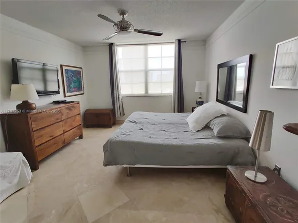 a bedroom with a large bed and windows