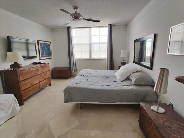 a bedroom with a large bed and windows