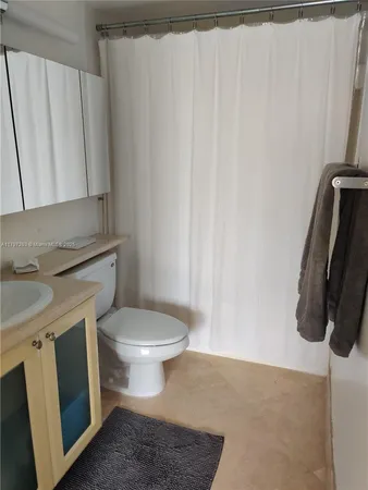 a bathroom with a granite countertop toilet and a sink