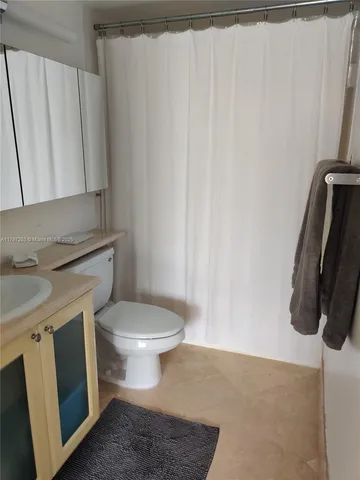a bathroom with a granite countertop toilet and a sink
