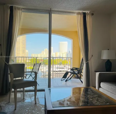 a living room with large window and dining table