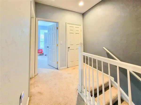 a view of staircase with railing and white walls