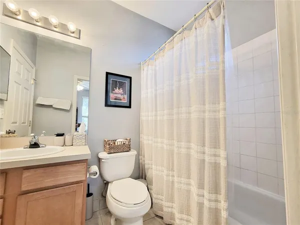 a bathroom with a sink a toilet and shower curtain