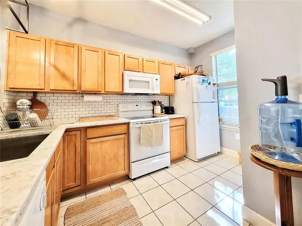 a kitchen with white cabinets and white appliances