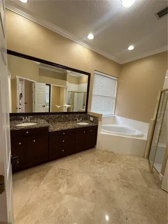 a spacious bathroom with a granite countertop sink a mirror and a bathtub