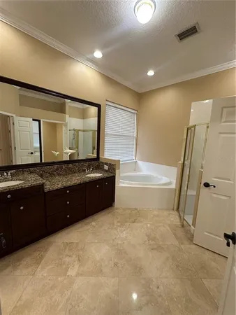 a spacious bathroom with a granite countertop sink a mirror and a bathtub
