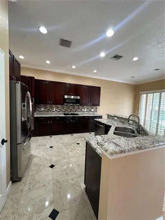 a kitchen with stainless steel appliances granite countertop a sink stove and refrigerator