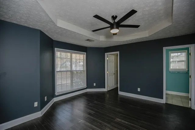 a view of a livingroom with wooden floor and a ceiling fan