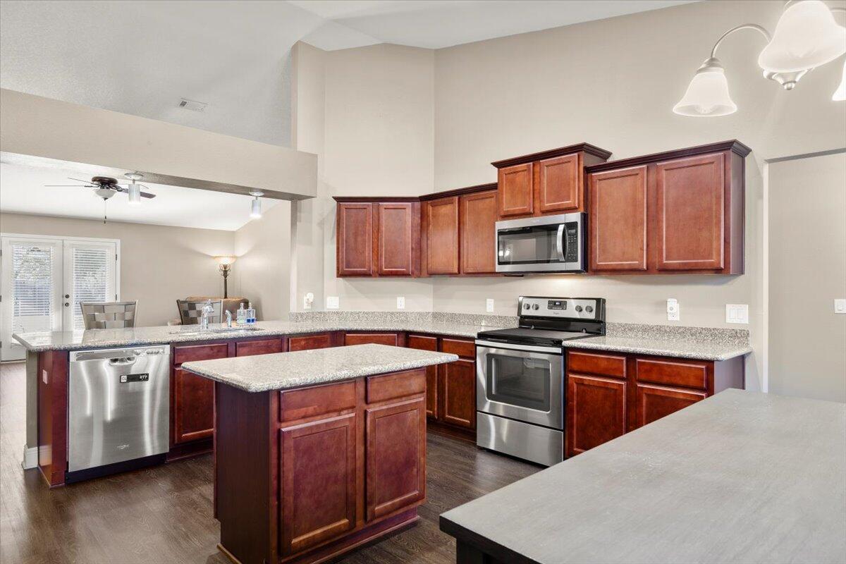 a kitchen with stainless steel appliances granite countertop a sink stove and microwave