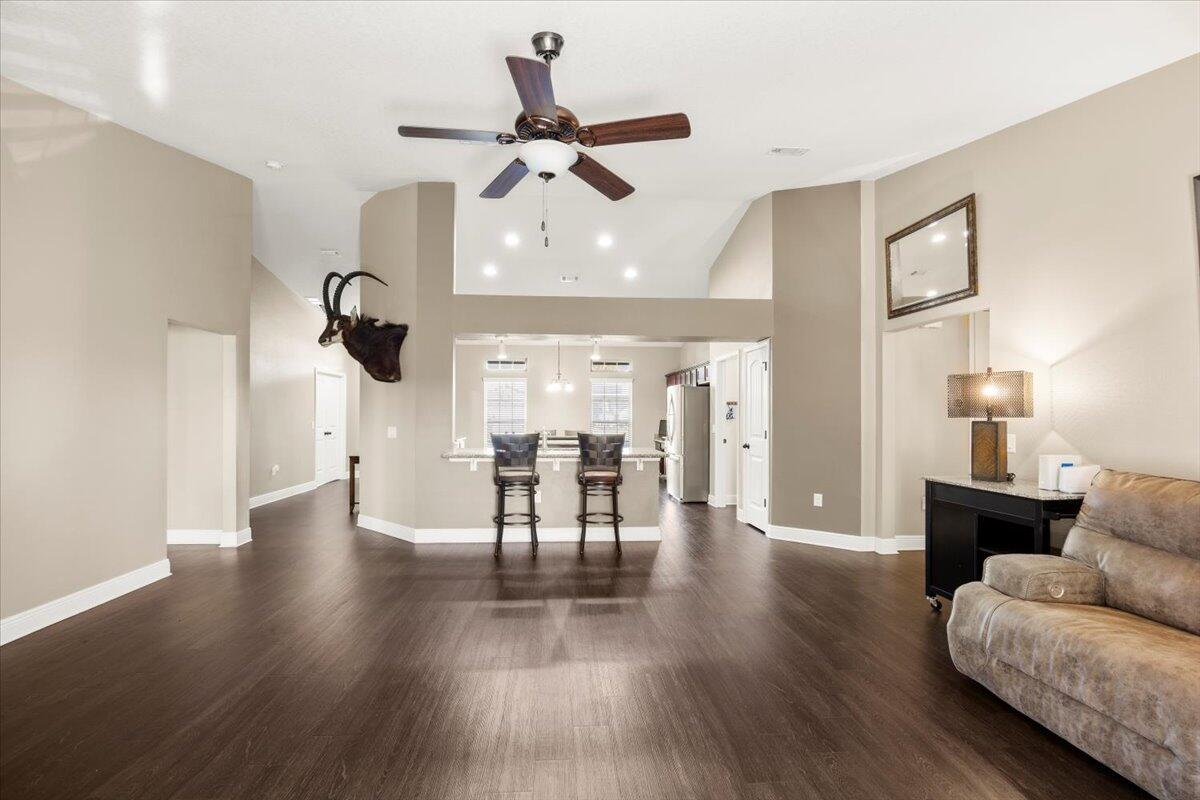5755 Stream Mill Way Pace, FL 32571 - Photo 12 of 29 a view of a livingroom with furniture wooden floor a ceiling fan and a kitchen view