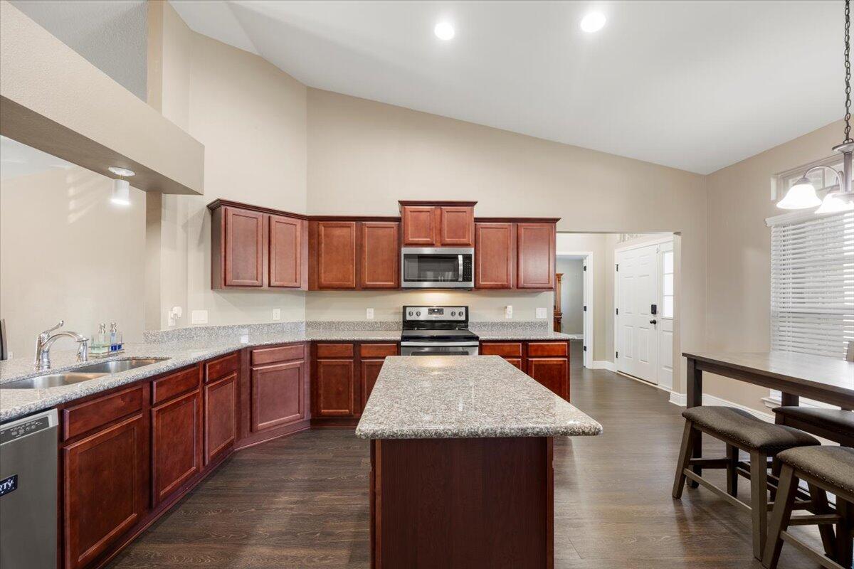 5755 Stream Mill Way Pace, FL 32571 - Photo 16 of 29 a kitchen with stainless steel appliances granite countertop wooden cabinets a sink dishwasher and a stove top oven with wooden floor