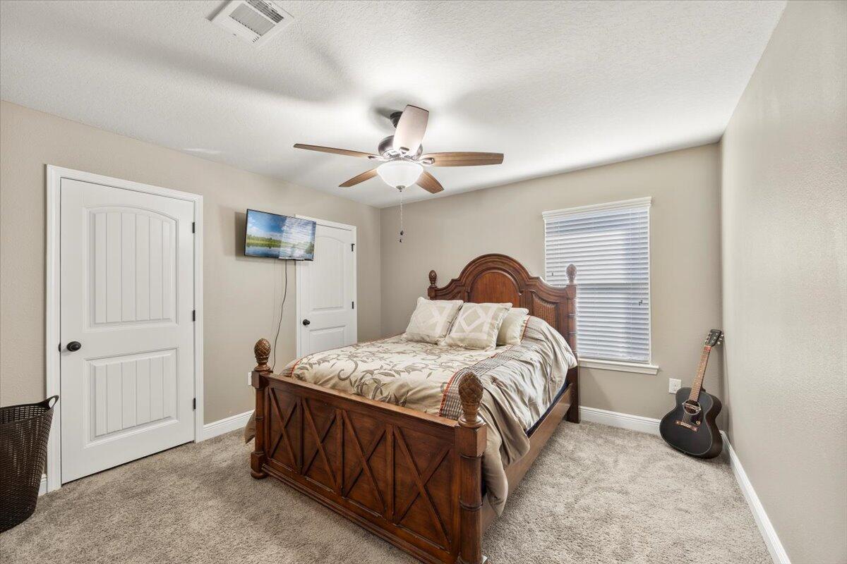 5755 Stream Mill Way Pace, FL 32571 - Photo 10 of 29 a bedroom with a bed and a chandelier