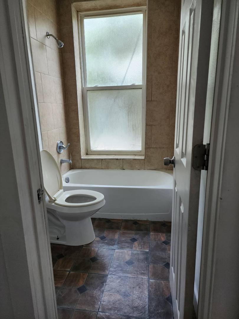 101 South Comstock Street, Unit 1 Joliet, IL 60436 - Photo 11 of 11 a bathroom with a toilet a sink and a bathtub