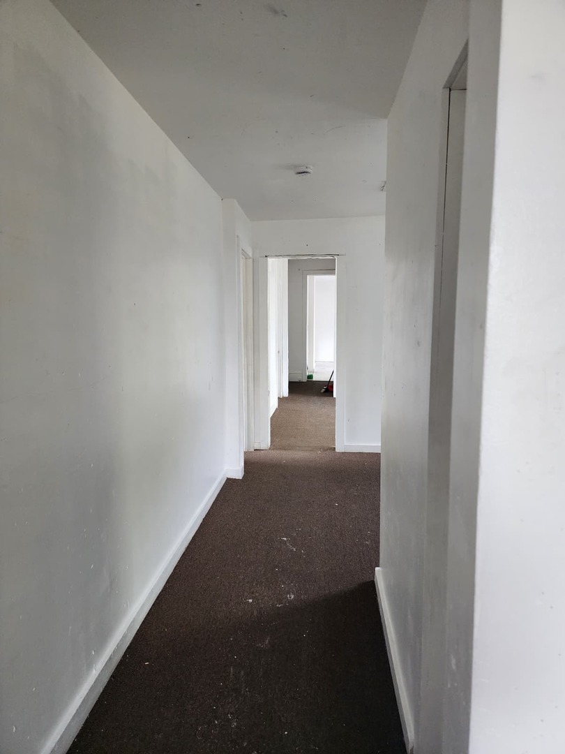 101 South Comstock Street, Unit 1 Joliet, IL 60436 - Photo 5 of 11 a view of a hallway with wooden floor