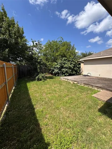 a view of yard with swimming pool and trees in the background