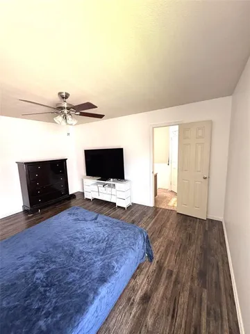 a living room with a bed furniture and a flat screen tv