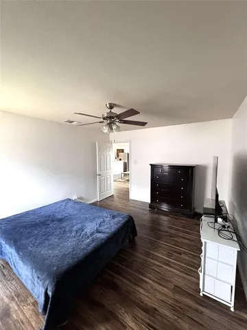 a spacious bedroom with a bed and a television