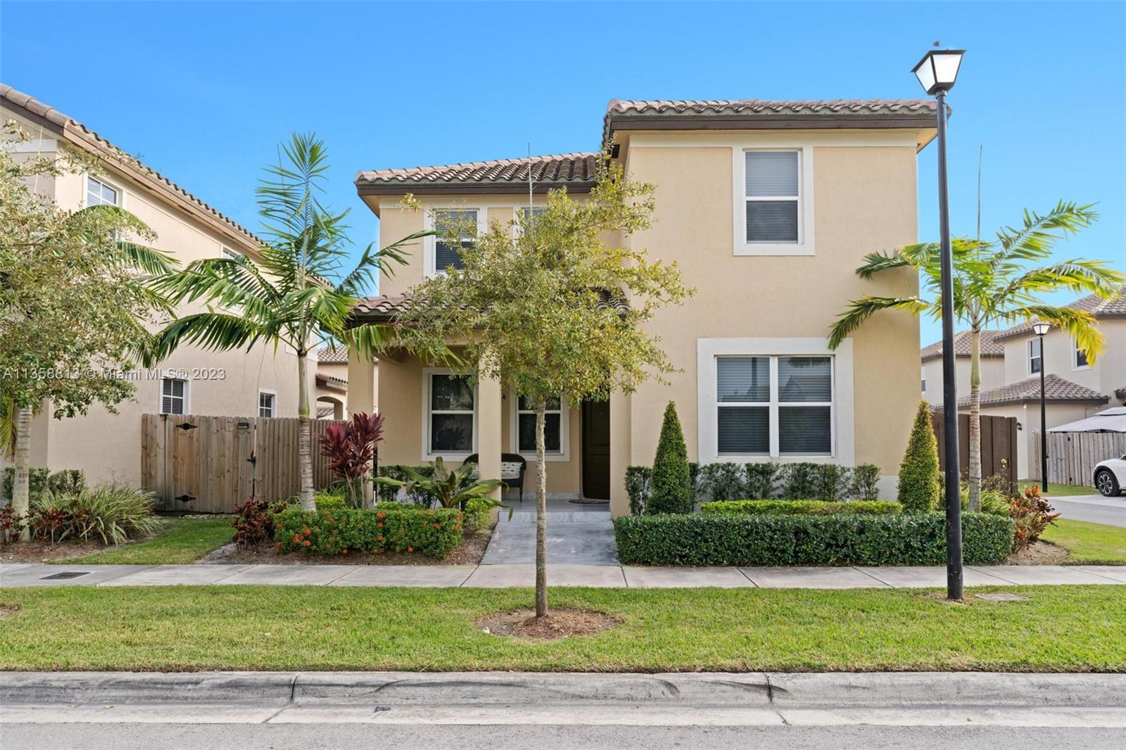 11744 Southwest 244 Street Homestead, FL 33032 - Photo 2 of 32 a front view of a house with a garden and plants