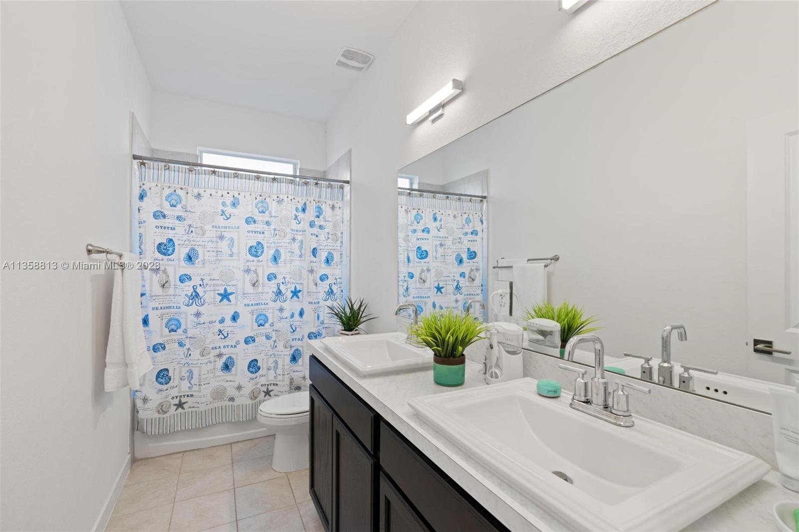 11744 Southwest 244 Street Homestead, FL 33032 - Photo 23 of 32 a bathroom with a sink a toilet and shower curtain