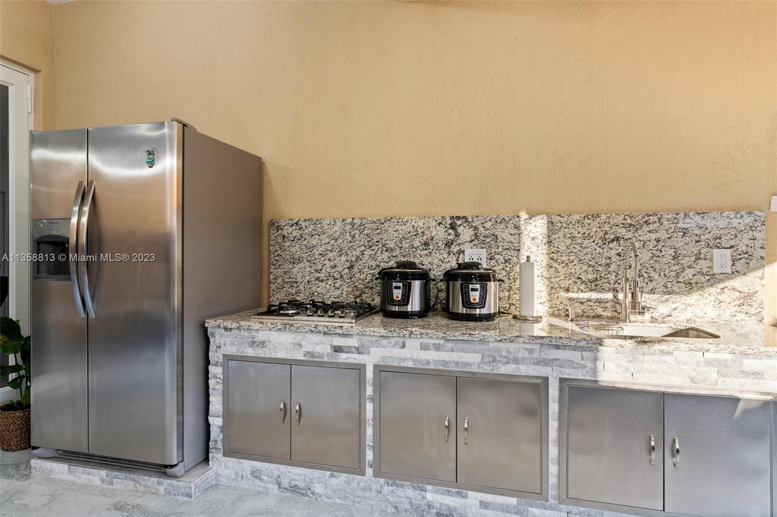 11744 Southwest 244 Street Homestead, FL 33032 - Photo 27 of 32 a kitchen with stainless steel appliances granite countertop a sink and a refrigerator
