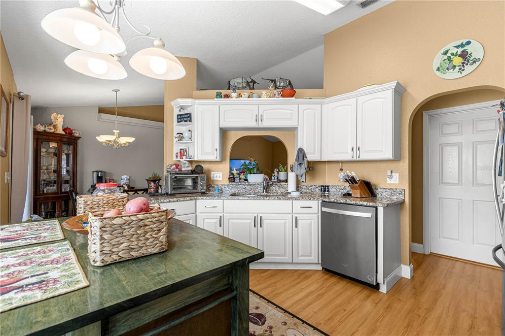 12459 Southeast 176th Loop Summerfield, FL 34491 - Photo 13 of 34 a kitchen with kitchen island granite countertop wooden cabinets a stove and a sink