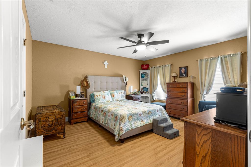 12459 Southeast 176th Loop Summerfield, FL 34491 - Photo 18 of 34 a bedroom with a bed and wooden floor