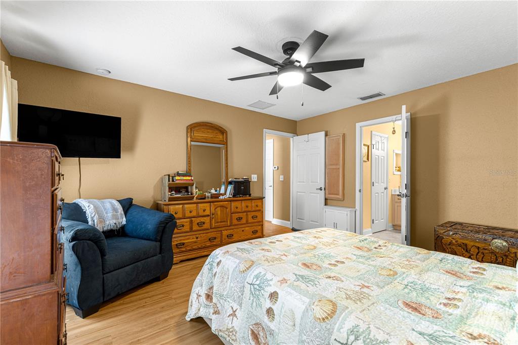 12459 Southeast 176th Loop Summerfield, FL 34491 - Photo 19 of 34 a bedroom with a bed a couch and a flat screen tv