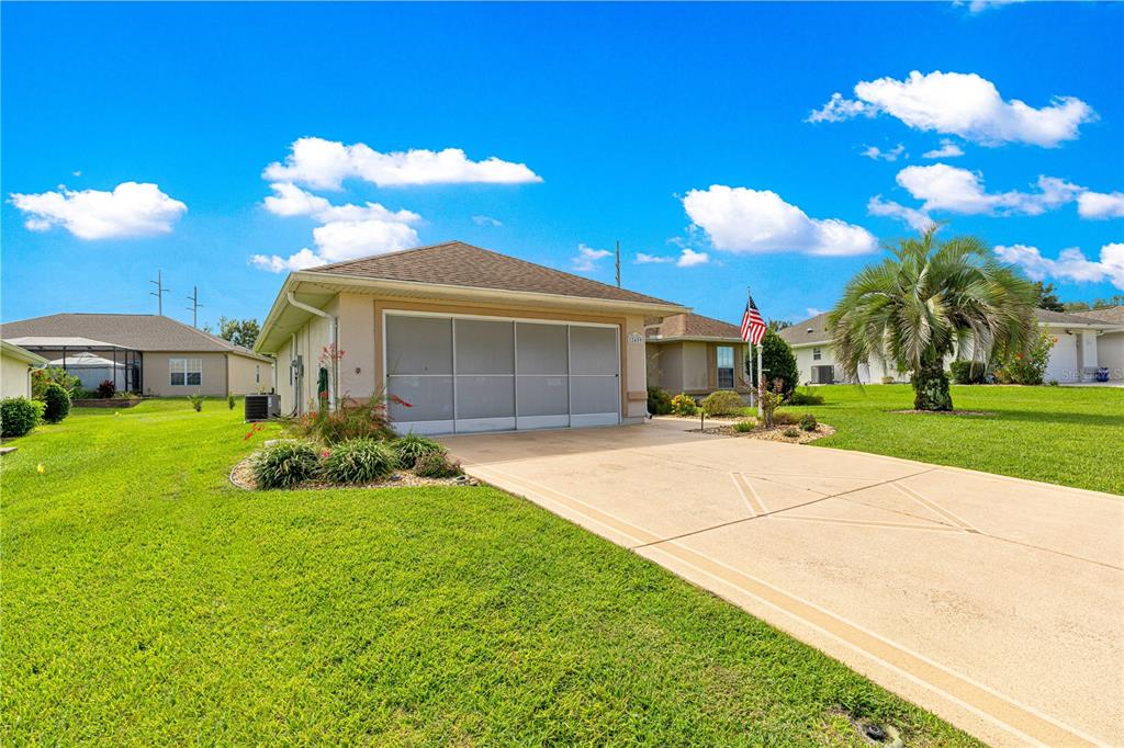 12459 Southeast 176th Loop Summerfield, FL 34491 - Photo 2 of 34 a front view of a house with a yard and garage