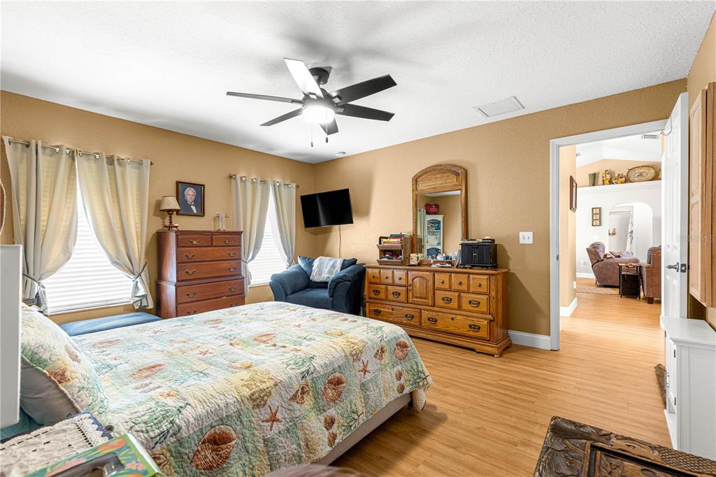 12459 Southeast 176th Loop Summerfield, FL 34491 - Photo 23 of 34 a bedroom with a large bed and a chandelier