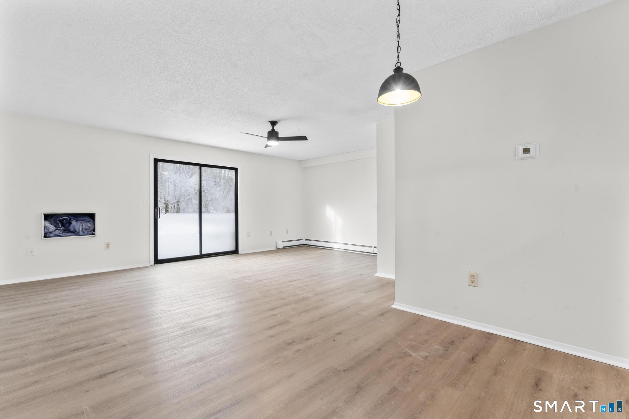 83 Sutton Place, Unit 83 Bloomfield, CT 06002 - Photo 11 of 29 a view of empty room with wooden floor and fan