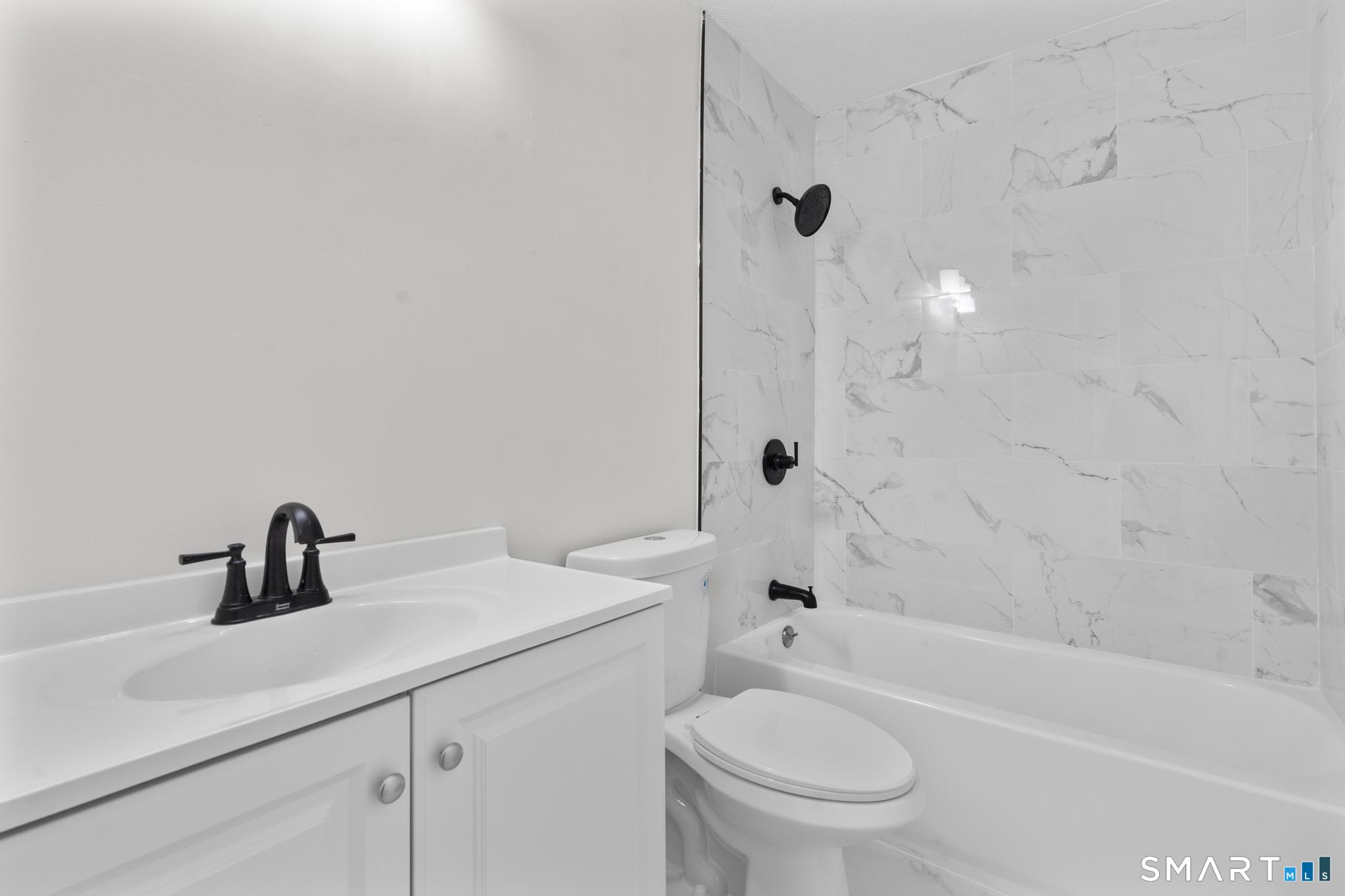 83 Sutton Place, Unit 83 Bloomfield, CT 06002 - Photo 17 of 29 a bathroom with a sink a toilet and a bathtub