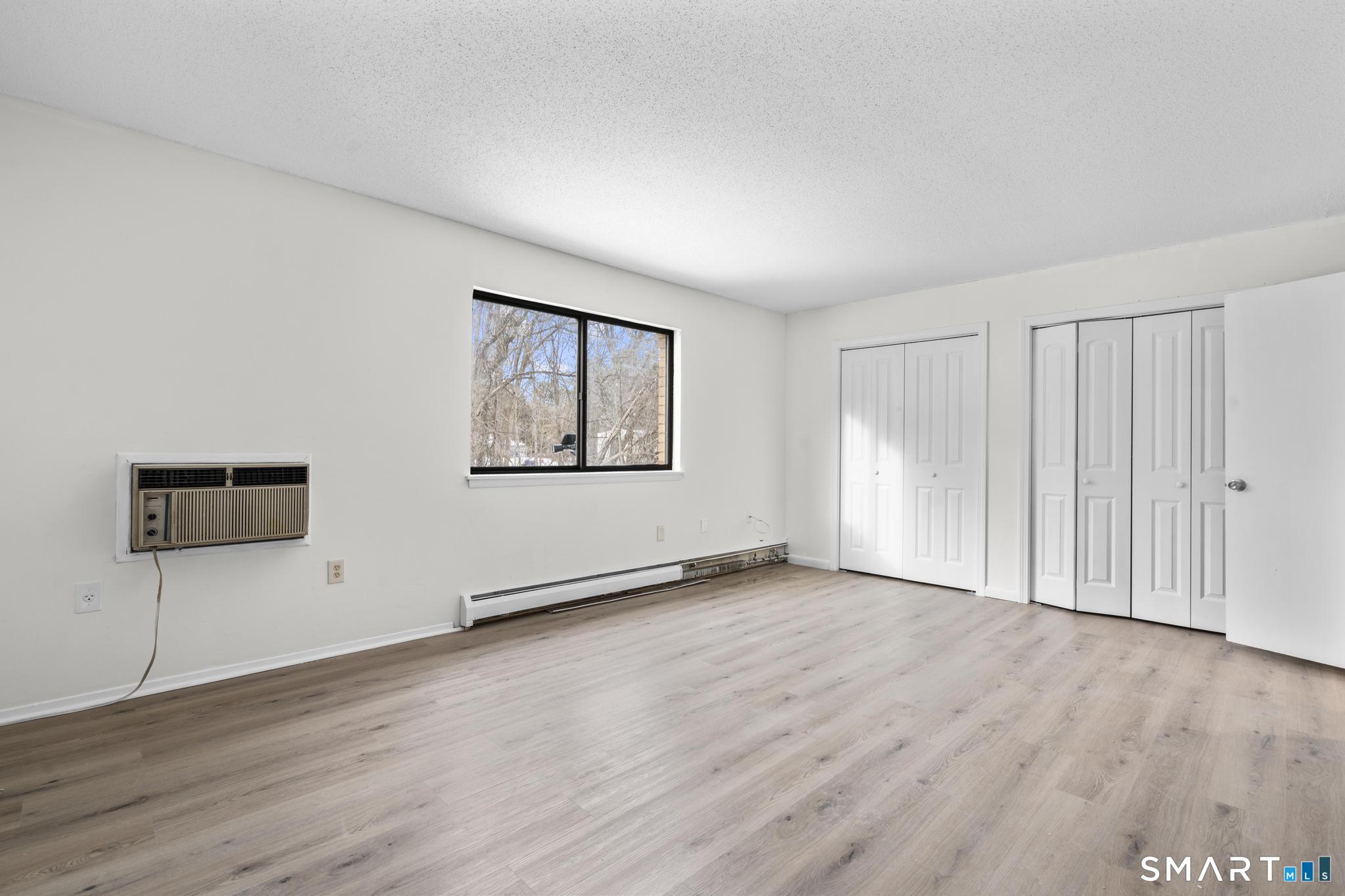 83 Sutton Place, Unit 83 Bloomfield, CT 06002 - Photo 20 of 29 an empty room with wooden floor and windows
