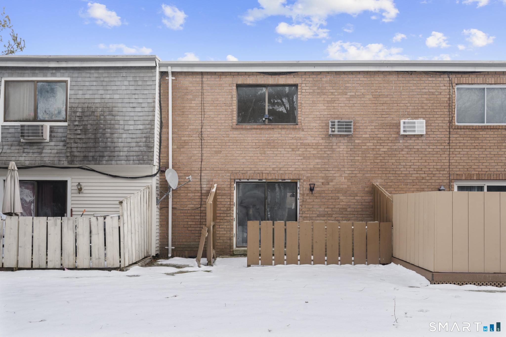 83 Sutton Place, Unit 83 Bloomfield, CT 06002 - Photo 2 of 29 a view of a house with a wooden fence